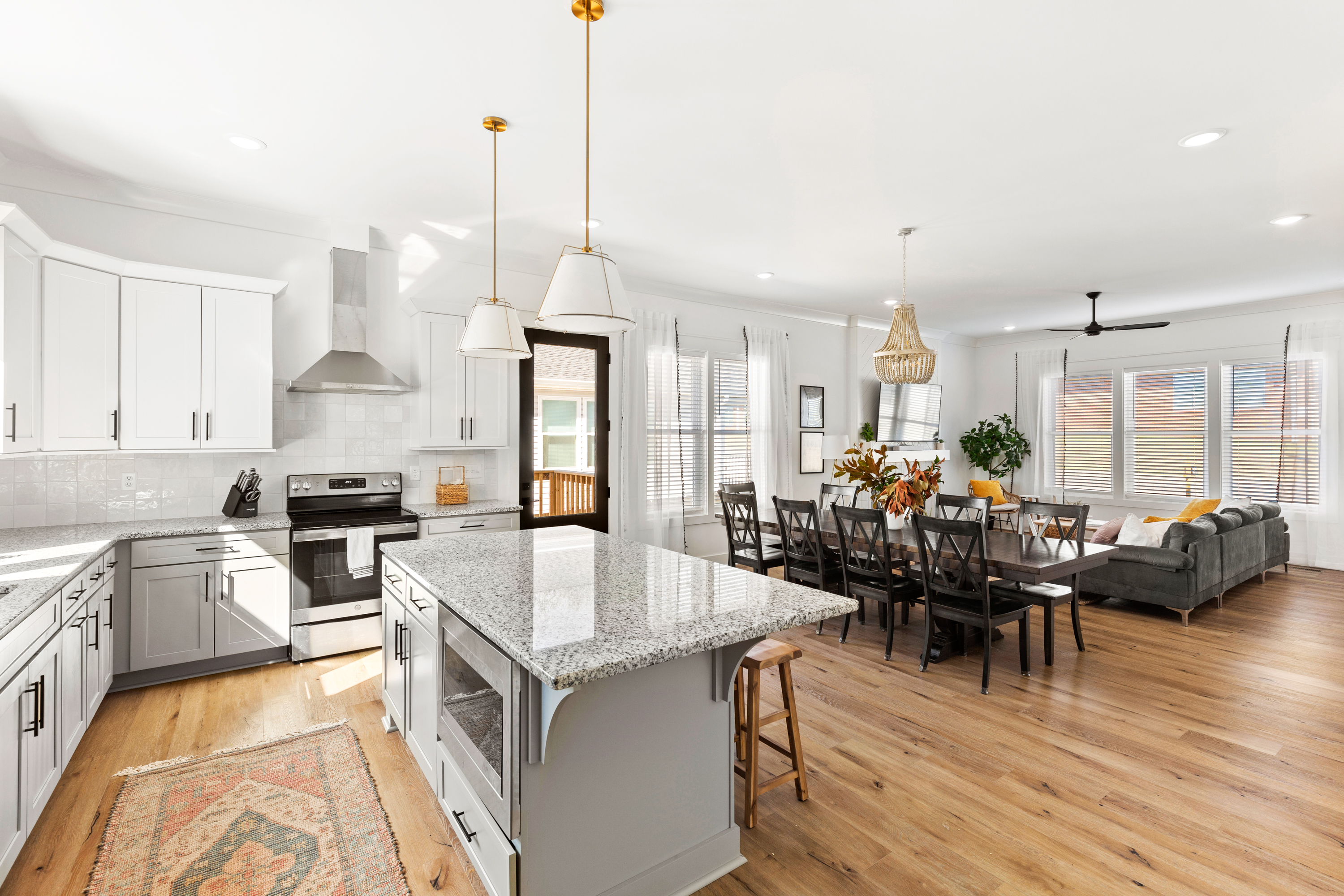 Open-concept kitchen and dining area with cozy living room in the background